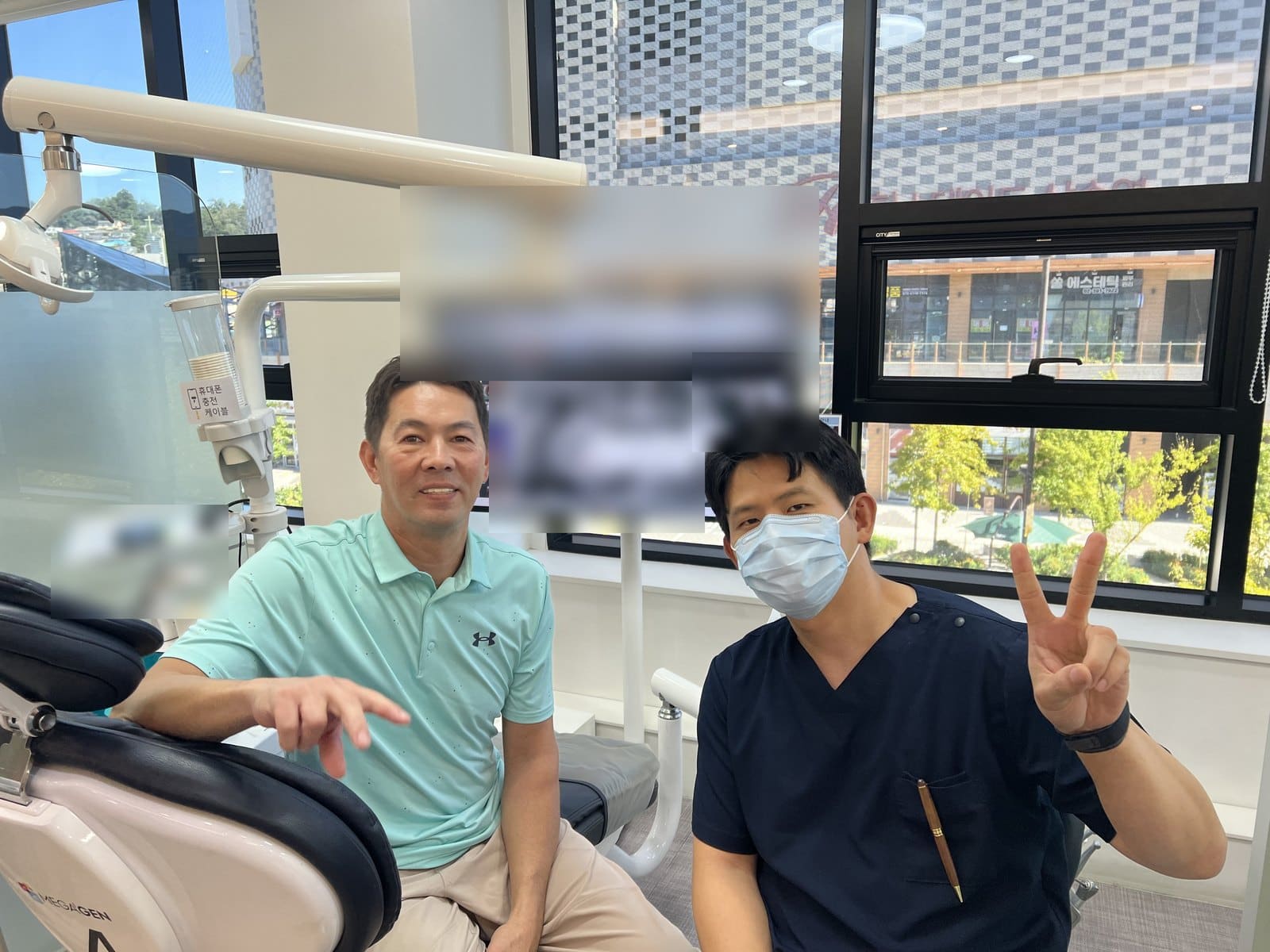 James, an international patient, with Dr. Doh beside the treatment chair after his implant treatment