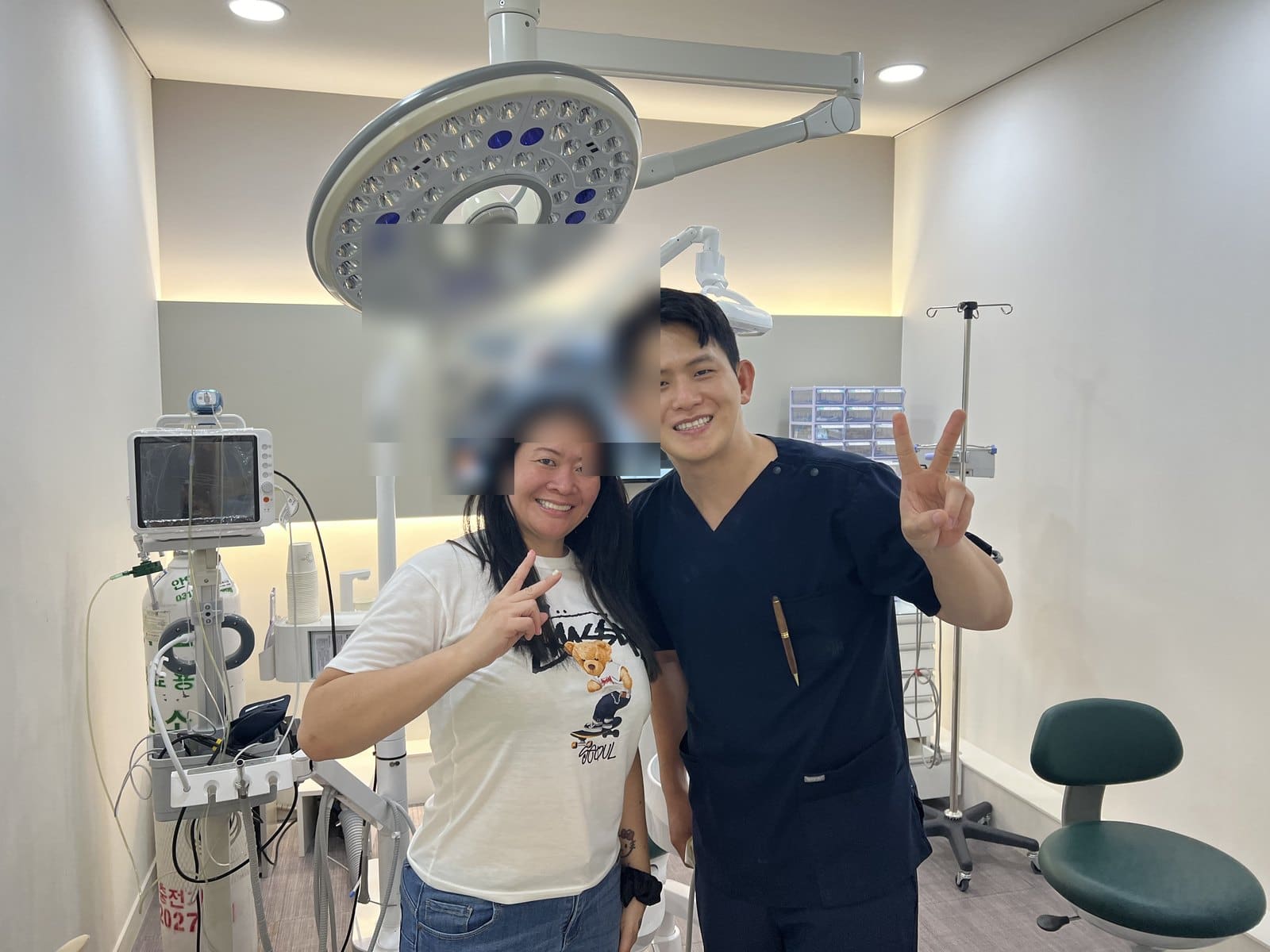 Jasmin, an international patient, smiling with Dr. Doh in the implant surgery room after completing her full-mouth implant treatment
